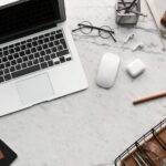 flatlay display of electronics next to eyeglases