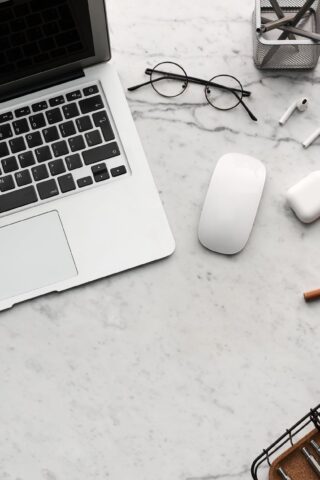 flatlay display of electronics next to eyeglases